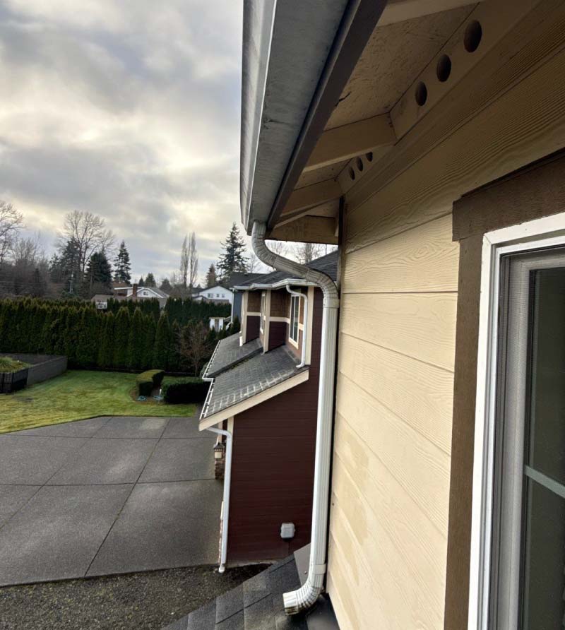 Close-up of a professionally installed K-style gutter system and downspout on a residential home, integrated with premium fiber cement siding, after gutter installation in tacoma