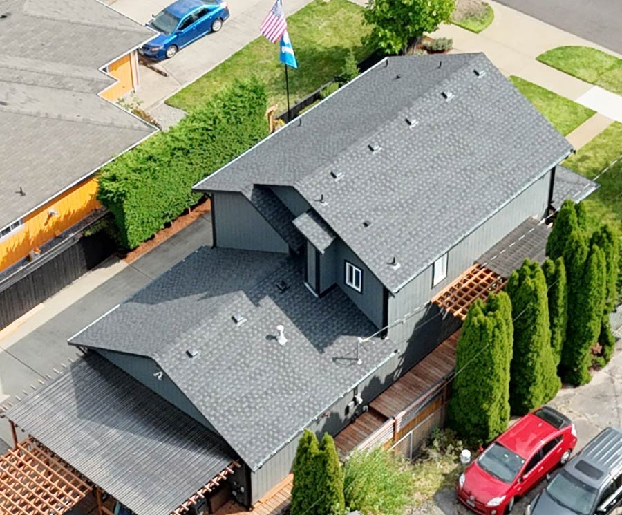 Finished full roof replacement on a modern grey home in Tacoma, demonstrating clean lines, expert flashing work, and the "Final Touch" quality standard in roofing.