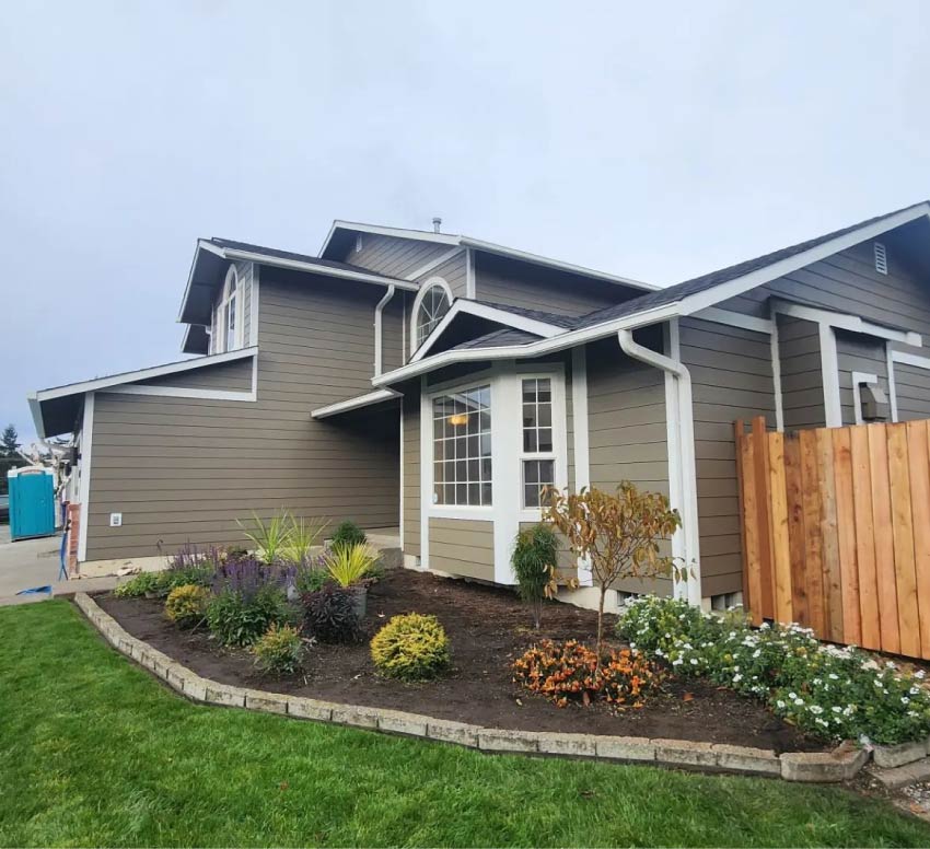 Expertly installed horizontal lap siding and clean white fascia boards on a modern Pacific Northwest home, demonstrating superior building envelope protection.