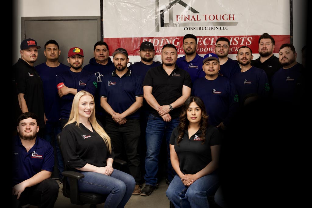 Final-touch-roofing-llc-team- Final Touch Construction LLC full team of roofing and siding specialists posing together in front of company banner at their Tukwila, Washington office, wearing branded navy uniforms with GAF certification patches