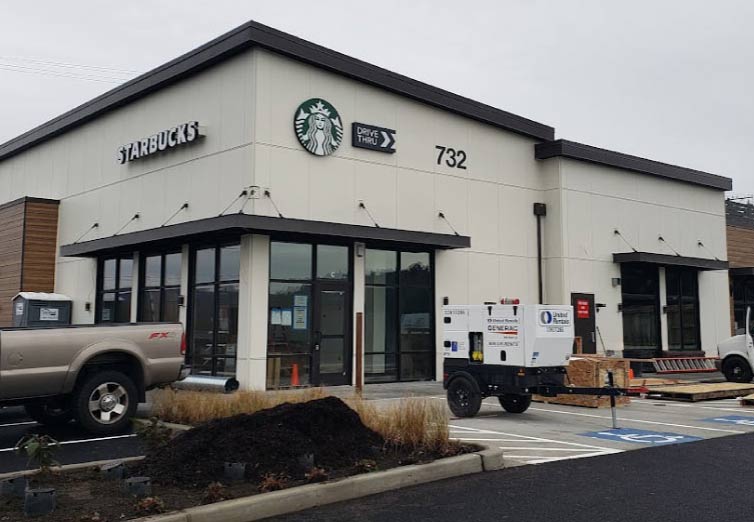 Large-scale commercial siding installation on an industrial facility in Seattle, showcasing durable metal wall panels and professional exterior infrastructure.