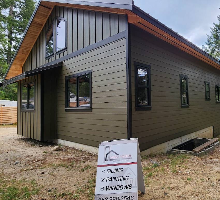 Detailed view of premium blue vertical and horizontal siding installation with integrated gutter and downspout systems for maximum moisture management.