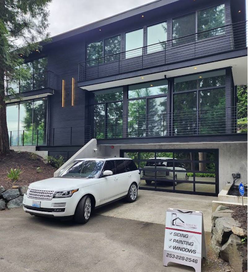 A stately multi-story residential home with dark brown siding and professional roofing, featuring complex gables and expert trim work by Final Touch Roofing & Siding repair