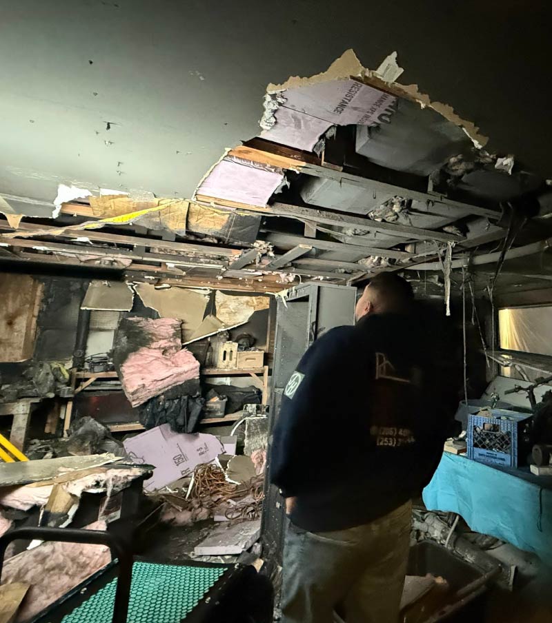 Internal view of a kitchen covered in debris after a ceiling collapse, highlighting the extensive cleanup and water mitigation & restoration work provided by IICRC-certified technicians.