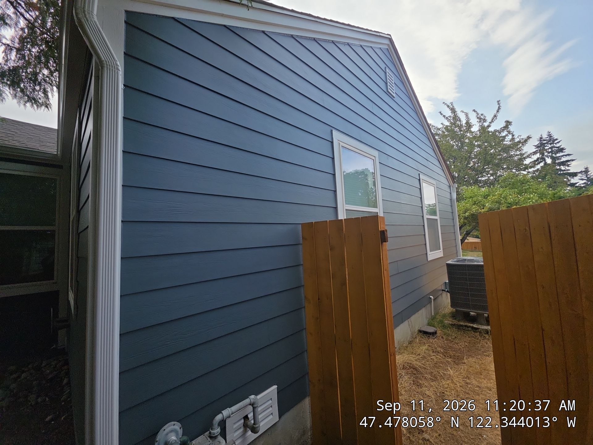 Clean roofline showing expert Fascia Repair and integrated gutter systems on a blue residential property with modern deck finishes.